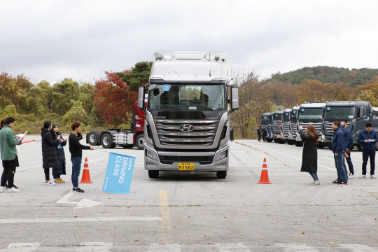 현대자동차가 지난 10일 충남 리솜 리조트에서 대형트럭 엑시언트 차주를 대상으로 실시한 '히어로 드라이빙 클래스' 참가자들이 이론 교육 이후 실습에 나서는 모습.<현대자동차 제공>